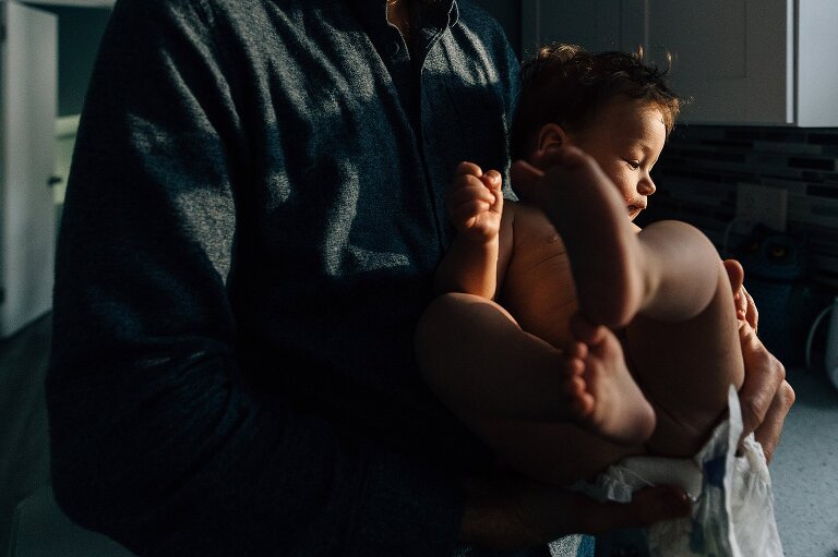 Father changes infant's diaper. 