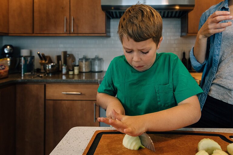 boy makes concentration face while cutting down on apple