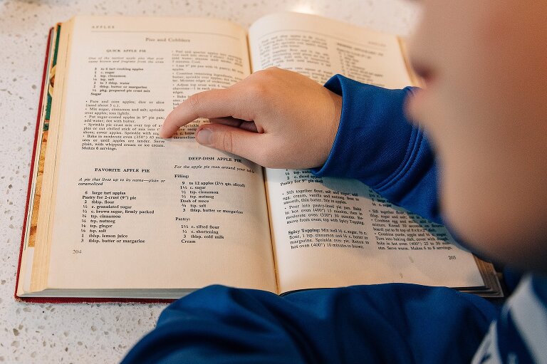 girl points to favorite apple pie recipe in an old cookbook Favorite Apple Pie