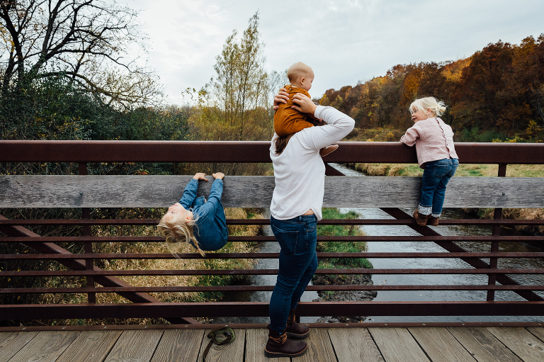 mom and three girls on bridge in an autumn forest 