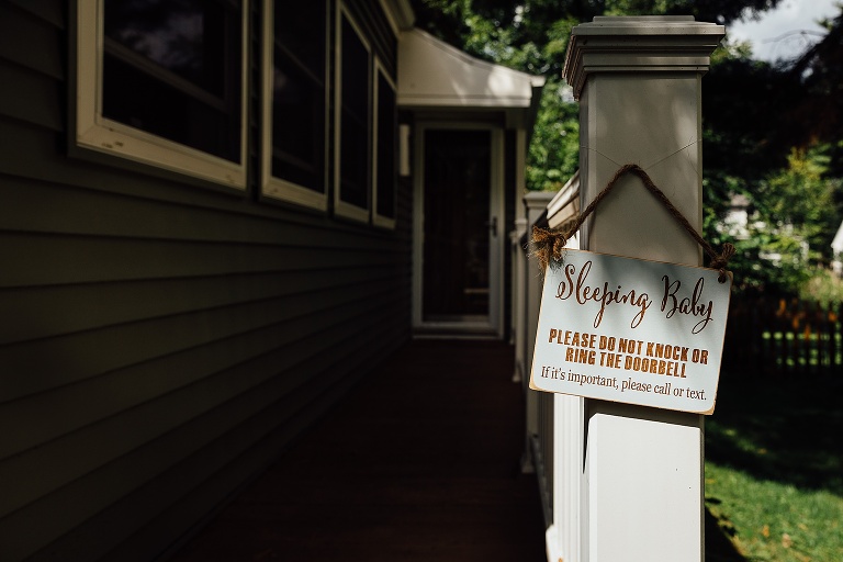 sign that reads sleeping baby outside the house 