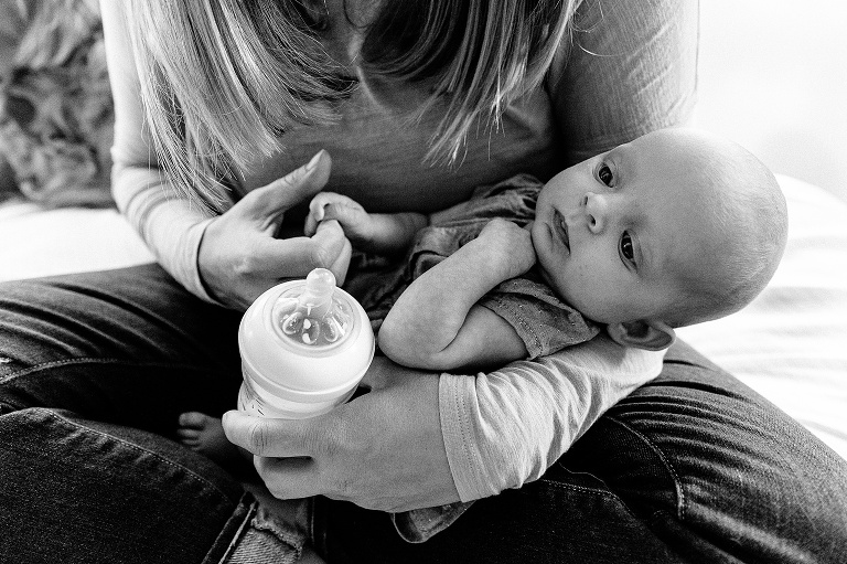 baby holds mom's hand; black and white