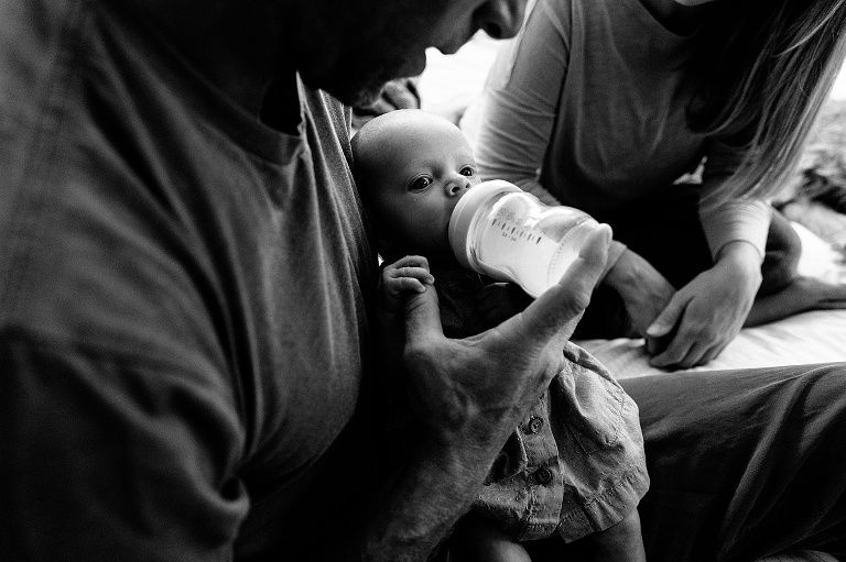 dad feeds baby via bottle 