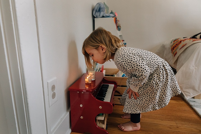 girl blows out candle on baby piano