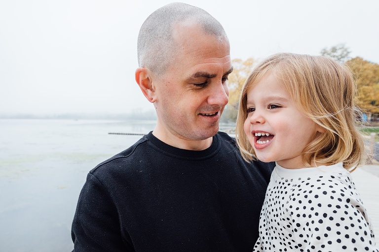 Dad and preschool daughter at the lake on a foggy fall weekend 