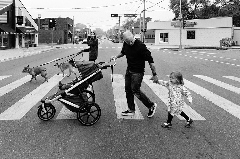Family of 4 and two dogs cross a busy urban street on a foggy fall weekend 