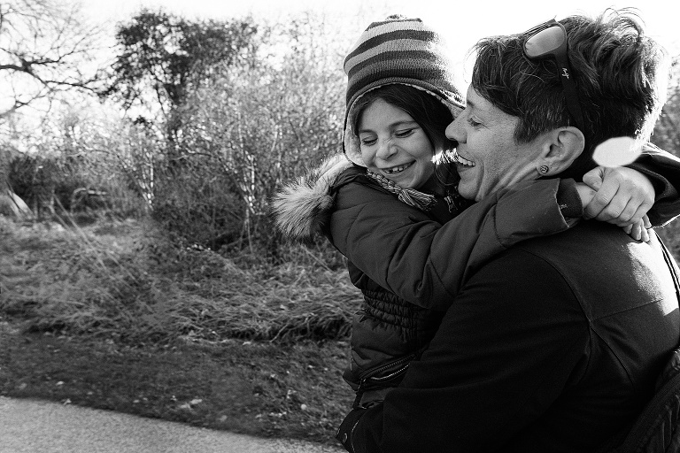 black and white, girl and mom smile while walk in a forest 