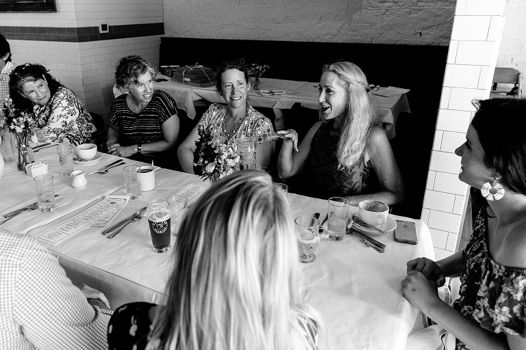 black and white; woman expressively gestures while other family members are engaged in her story
