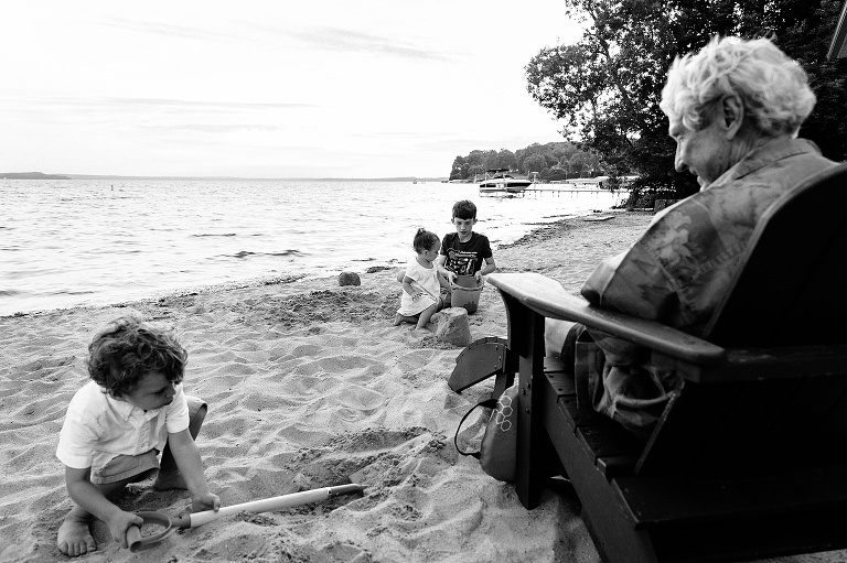 four people playing in the sand at the beach for an event photography session