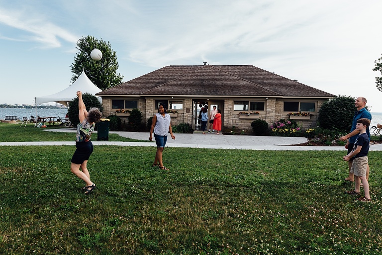 four family members play volleyball at the beach clubhouse for an event photography session