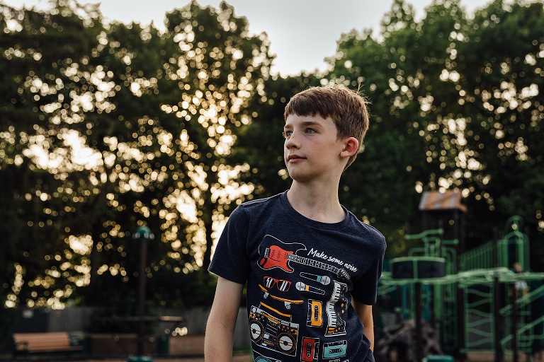 portrait of a young boy at the park at dusk