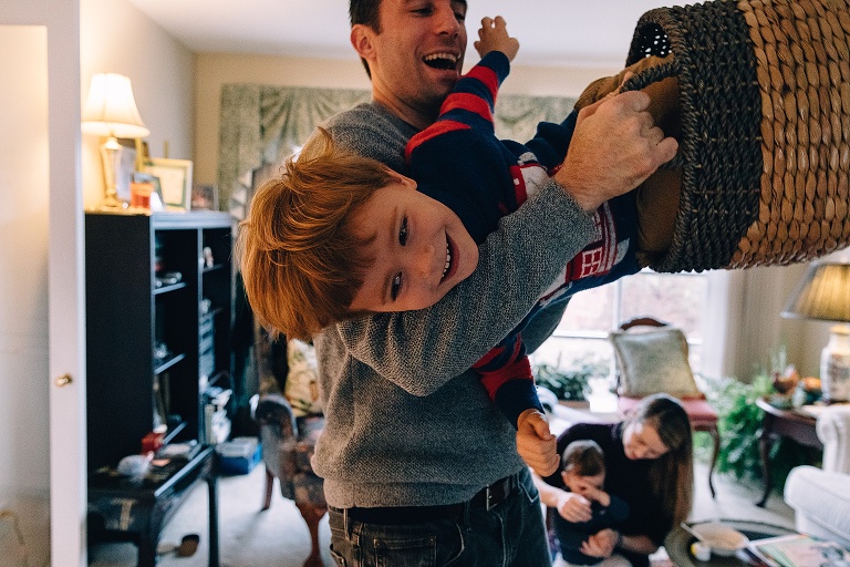 boy rides in a decorative basket that his father is holding