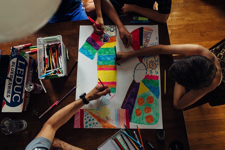 top view of family working on coloring in a giant numeral 10.