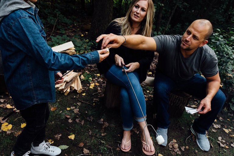 Dad reaches to help son assemble s'mores