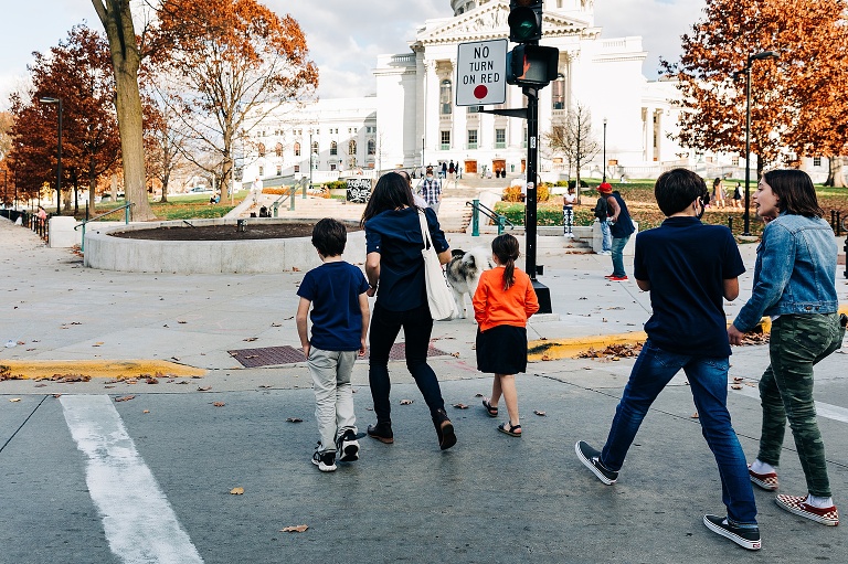 family of six and dog cross street in direction of Capitol building