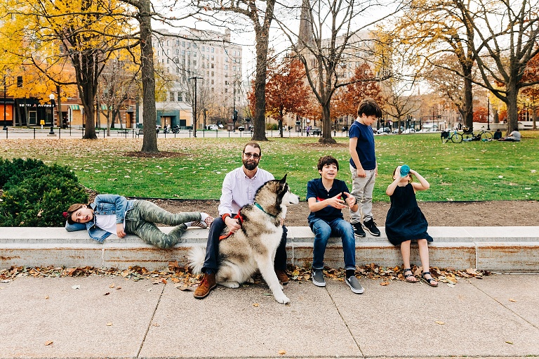Dad, dog, and four kids rest on Capitol lawn in a downtown Madison adventure day