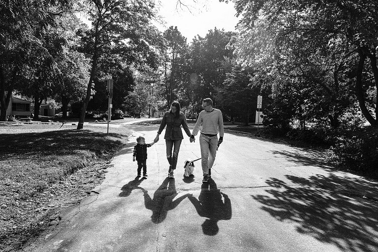 Family of 3 and dog go for a late morning walk, perfect shadows fall in front of them