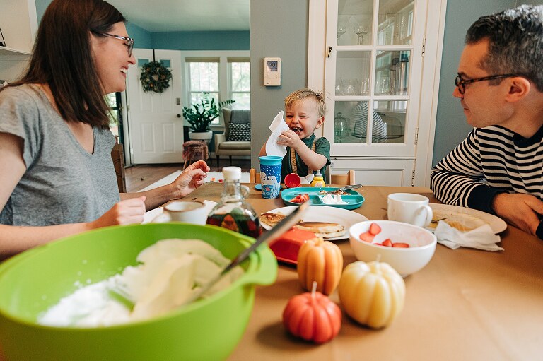 Family of three sit at the dining room table together
