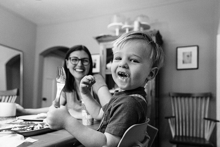 Happy toddler has mouth full of whipped cream on Saturday pancakes day