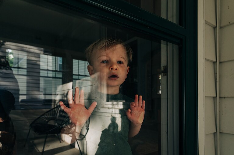 toddler looks out the front door 