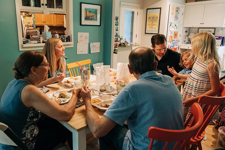 Extended family with grandparents have a meal at dining room table