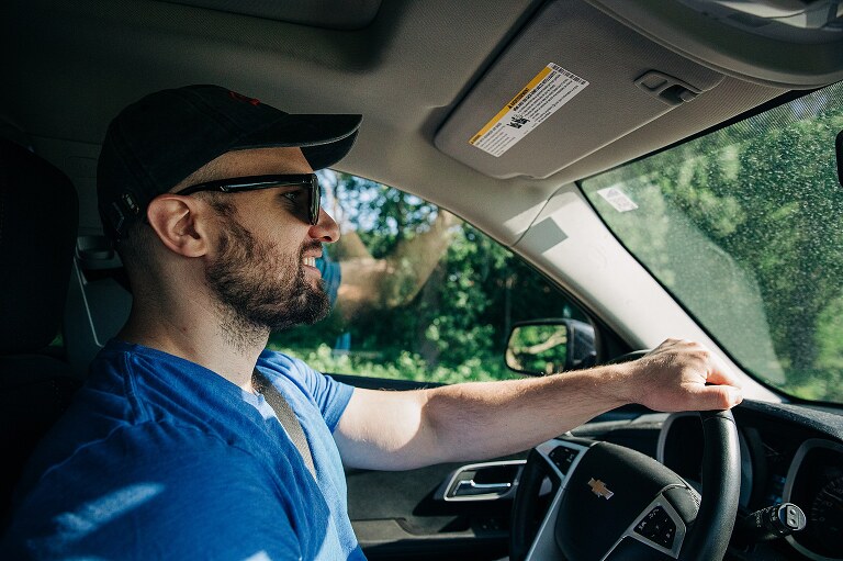 man drives car on a summer's day