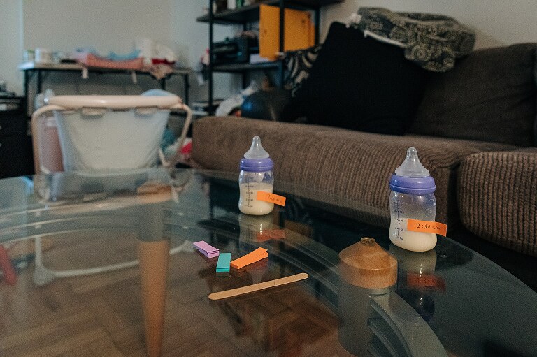 two baby bottles with sticky notes attached with the time and amount 