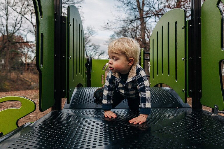 toddler in beautiful light on a play structure at the park