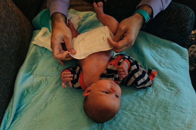 top down view of newborn getting diaper change on a couch