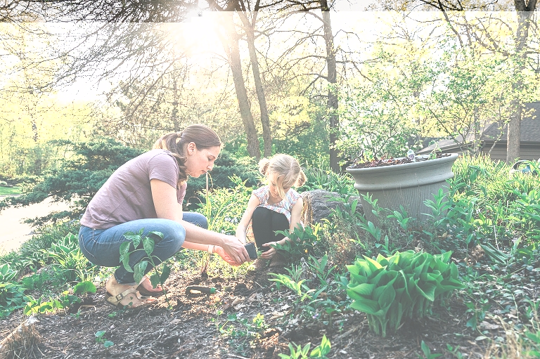 Mothers and daughter work in garden together 