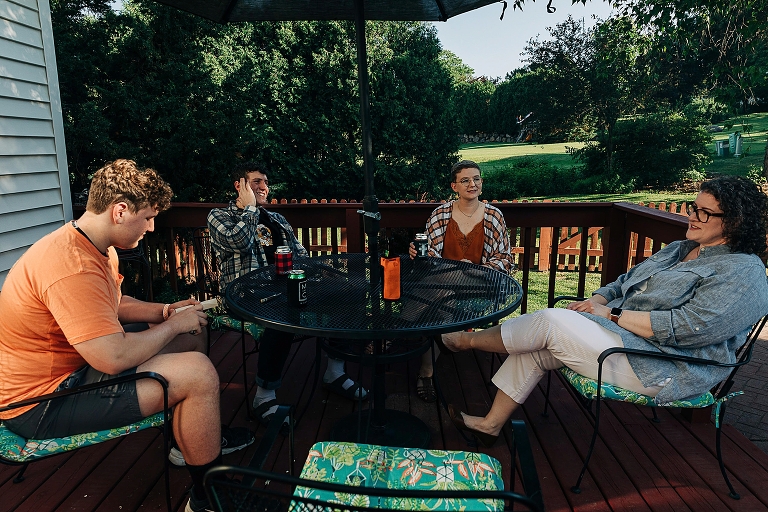 mothers sit at outdoor dining table with three adult children