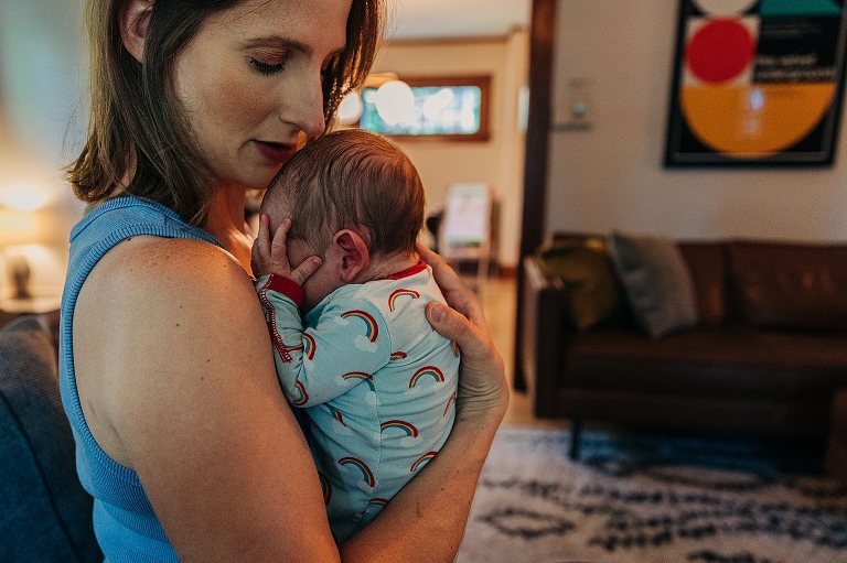 mothers hold newborn child in living room