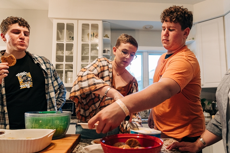 Eldest brother eats a cookie while adult sister and brother secure their desserts 