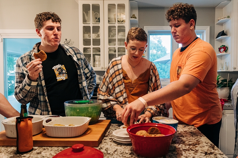 Two adult sons and adult daughter indulge in dessert inside of cookies and ice cream
