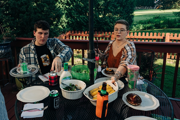Eldest son and adult daughter begin putting food on their plates just before meal "all together now"