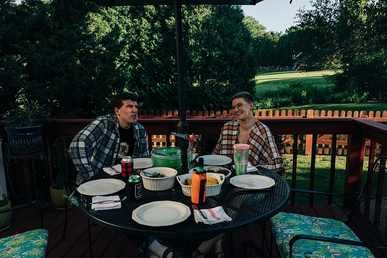 Eldest brother and adult sister converse at set patio table