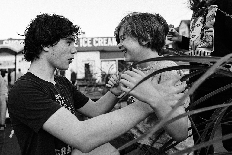 Black and white: Eldest brother plays with youngest on the patio of the ice cream restaurant 