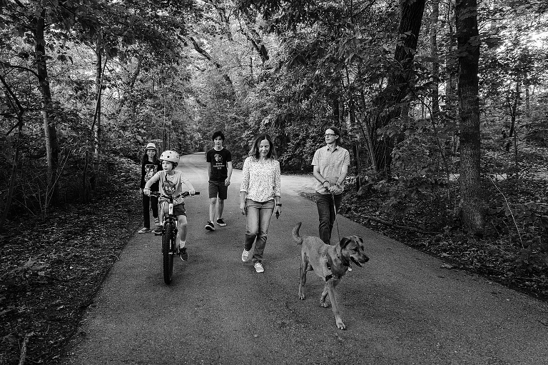 Wide shot, black and white: frontal view of the whole family on their walk in the late spring