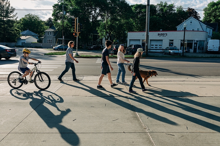 Wide shot: Family converses on their walk during the late spring
