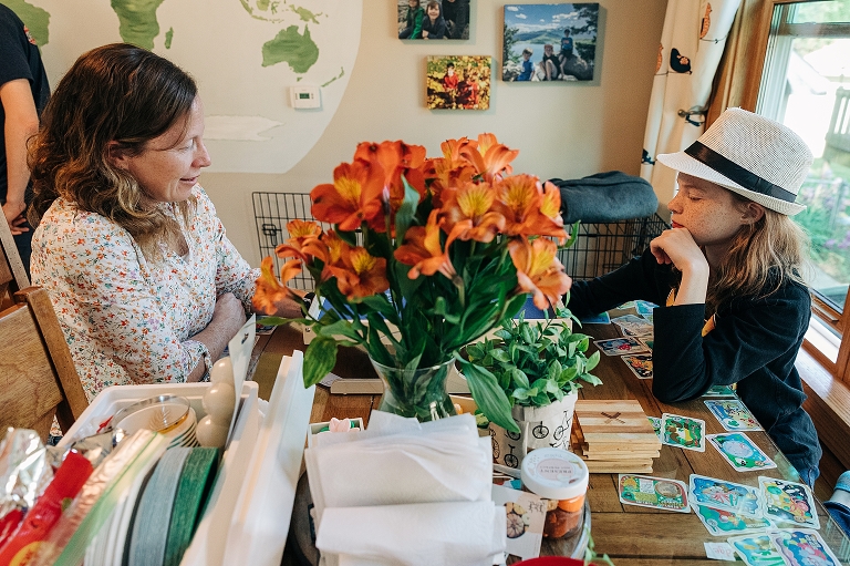 Middle son with fedora plays table Klask with mother 