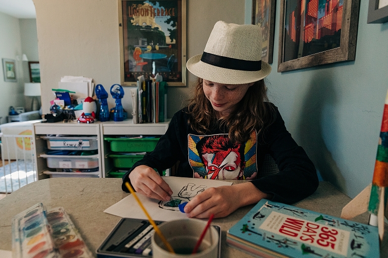 Middle son draws and colors an astronaut in family's kitchen 