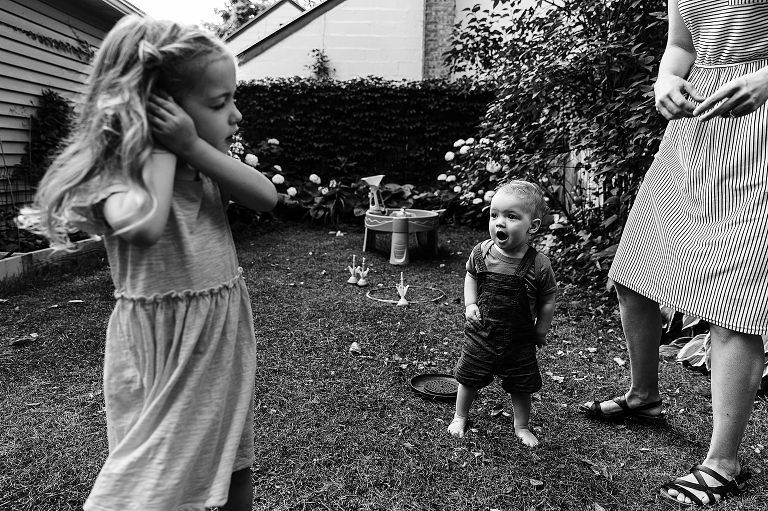 Elder daughter caresses ear while young son holds surprised expression 