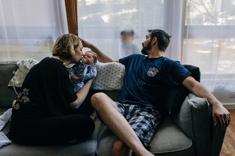 family hangs out on grey couch 