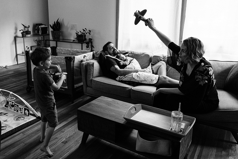 mother pays with toy airplane in living room 