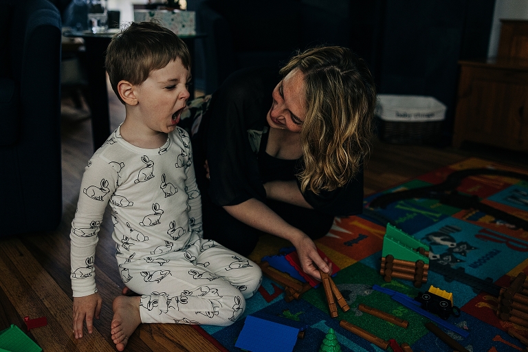 mother consoles young son as he yells at his toys 