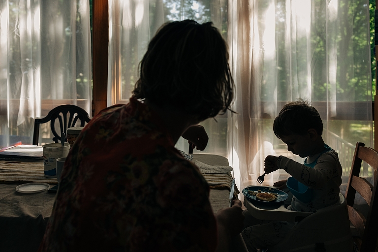 mother serves young son food at the breakfast table 