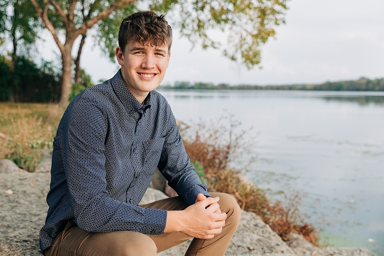 smiling senior boy pictures next to a lake