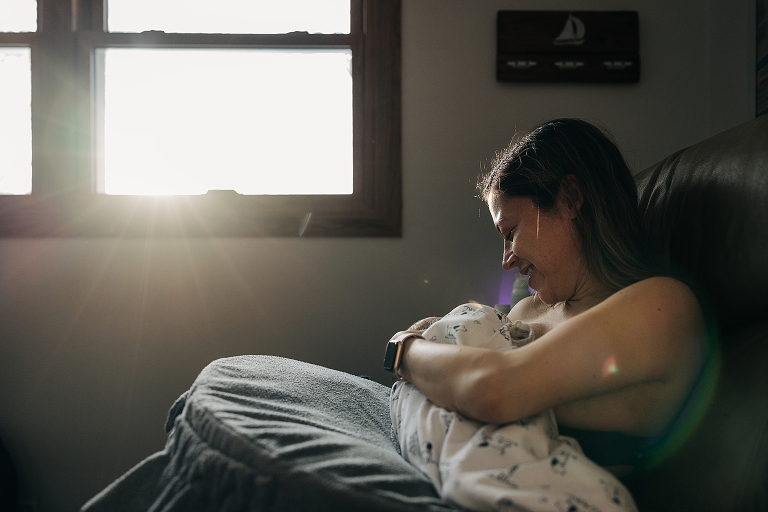 Brilliant winter light shines through the window onto nursing mother