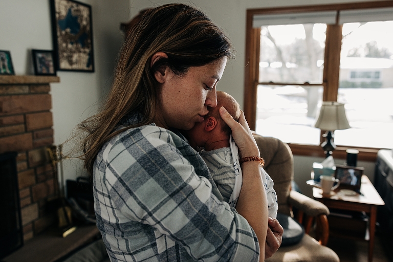 Mother gently holds newborn baby to her chest 