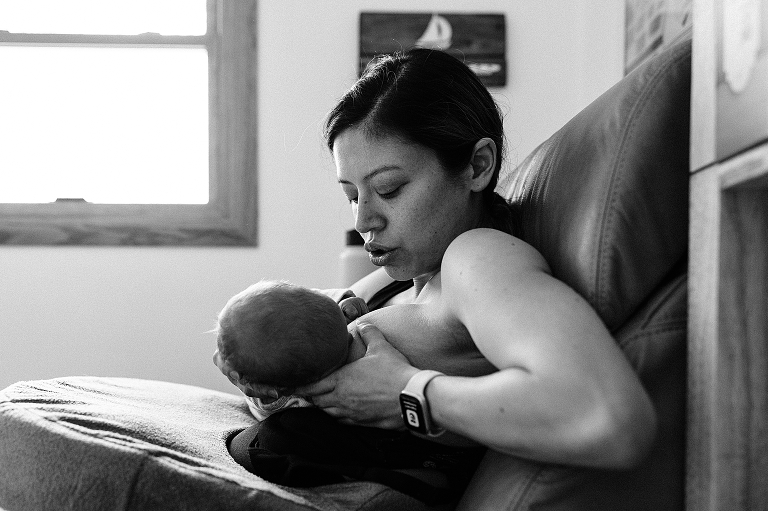 Mother shushes newborn baby while nursing at home on a winter's day